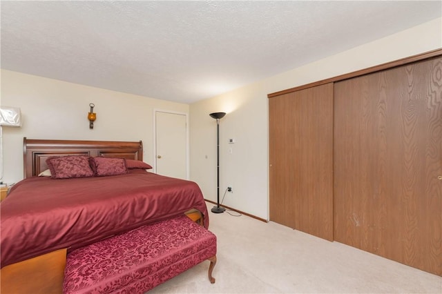 bedroom with light carpet, a closet, and a textured ceiling