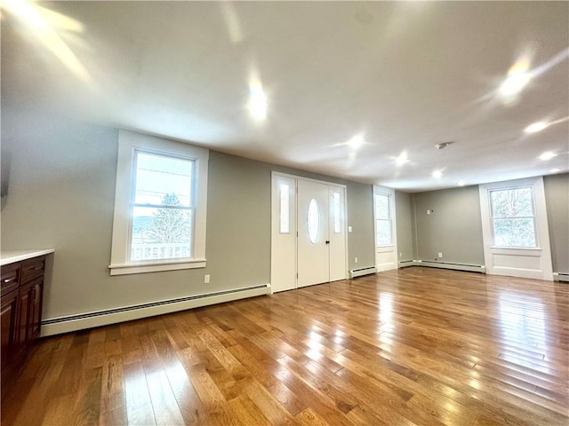 interior space with baseboard heating and light hardwood / wood-style flooring