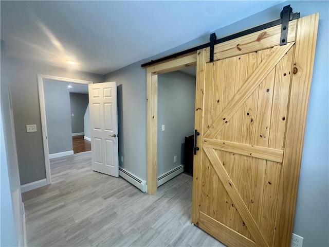 hall with a barn door, hardwood / wood-style flooring, and a baseboard radiator