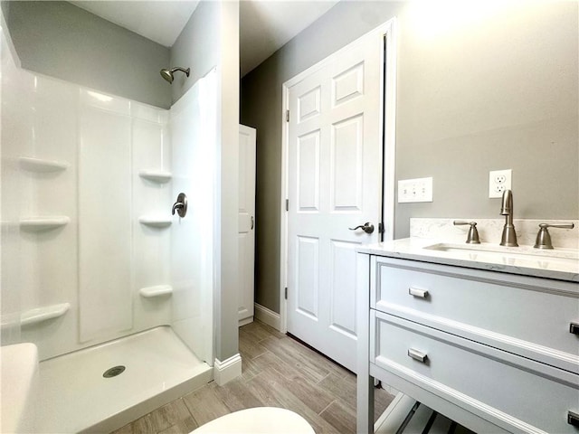 bathroom featuring walk in shower and vanity