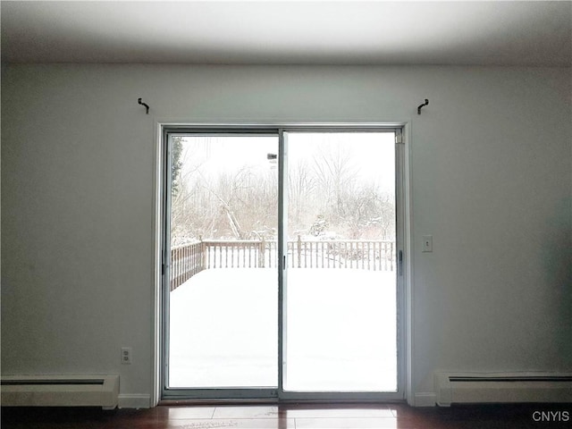 doorway to outside with hardwood / wood-style flooring and a baseboard heating unit