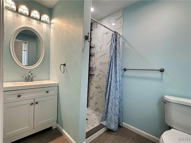 bathroom featuring toilet, a shower with shower curtain, hardwood / wood-style floors, and vanity