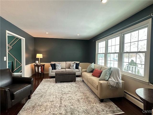 living room with baseboard heating and dark hardwood / wood-style flooring