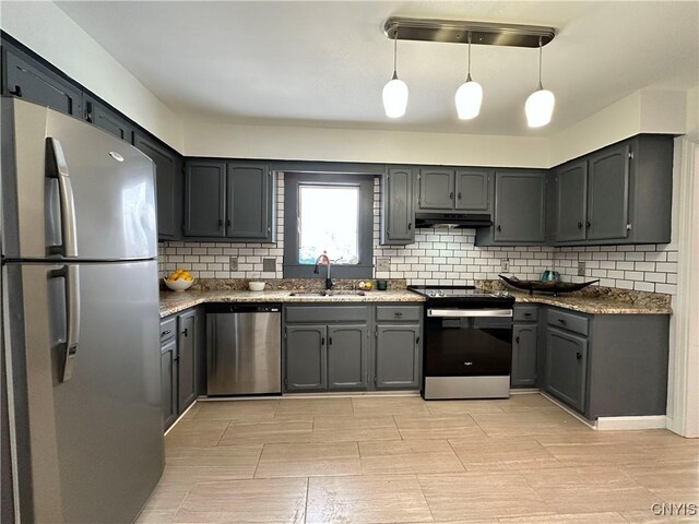 kitchen with backsplash, sink, stainless steel appliances, and pendant lighting