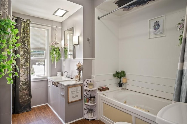 bathroom featuring hardwood / wood-style flooring, a tub to relax in, and vanity