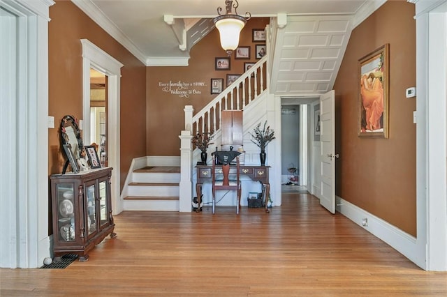 entryway featuring crown molding and light hardwood / wood-style floors