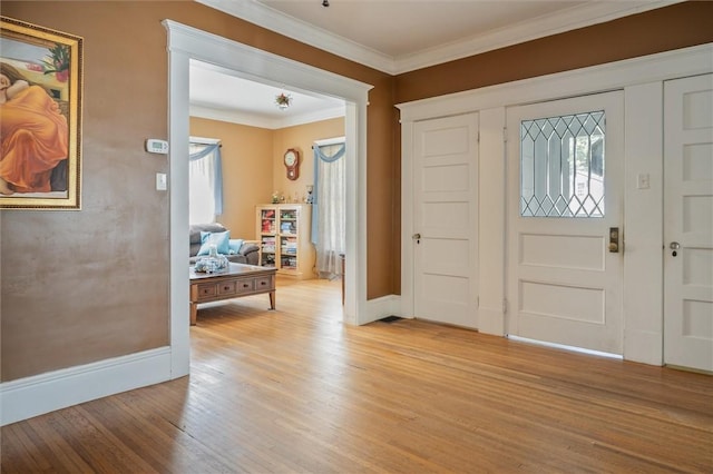 entrance foyer with ornamental molding and light hardwood / wood-style flooring