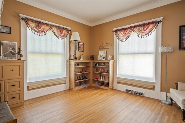 sitting room featuring light wood-type flooring and crown molding