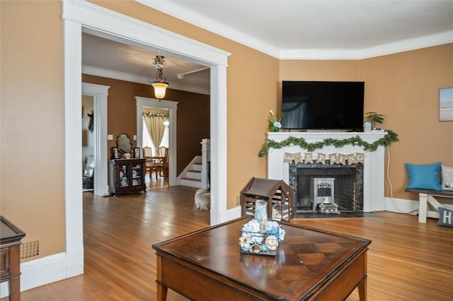 living room with wood-type flooring and ornamental molding