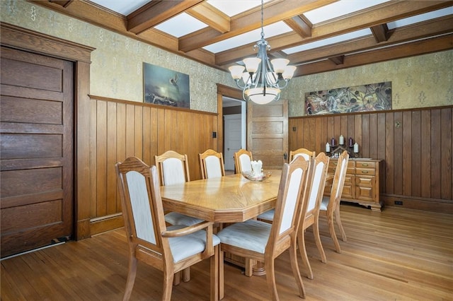 dining area featuring an inviting chandelier, light hardwood / wood-style floors, beam ceiling, and coffered ceiling