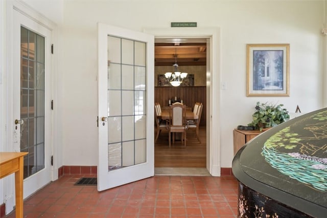 tiled bedroom with french doors and an inviting chandelier