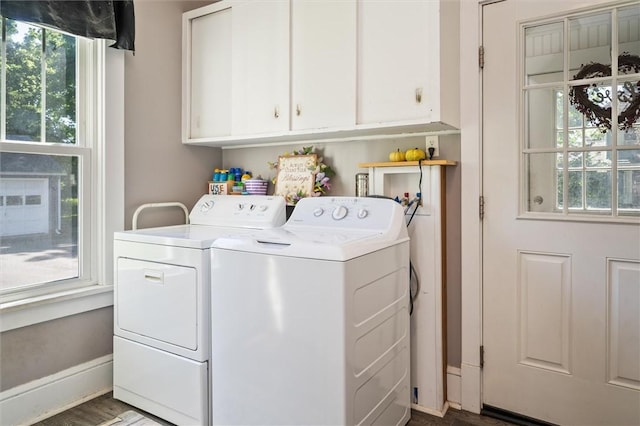 clothes washing area with cabinets, a healthy amount of sunlight, and washing machine and clothes dryer