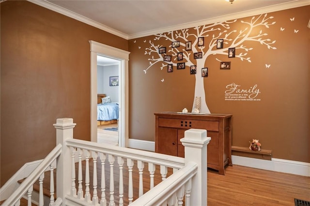 interior space with a nursery area, ornamental molding, and light hardwood / wood-style floors