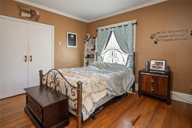 bedroom with a closet, ornamental molding, and wood-type flooring