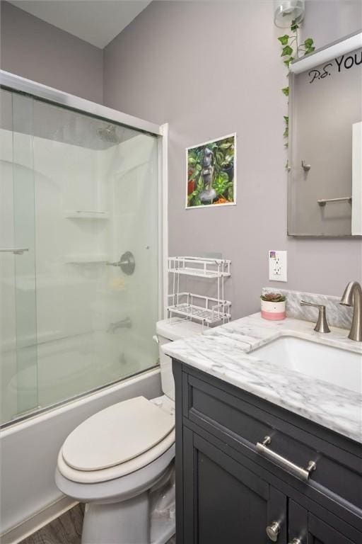 full bathroom featuring bath / shower combo with glass door, toilet, and vanity