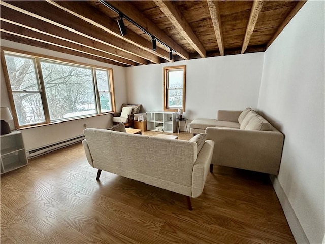 living area with a baseboard heating unit, wooden ceiling, a healthy amount of sunlight, and beam ceiling