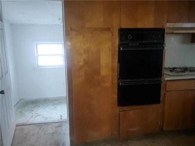 kitchen with double oven and white gas cooktop