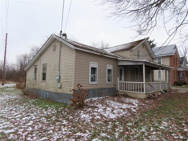 view of snow covered exterior with covered porch