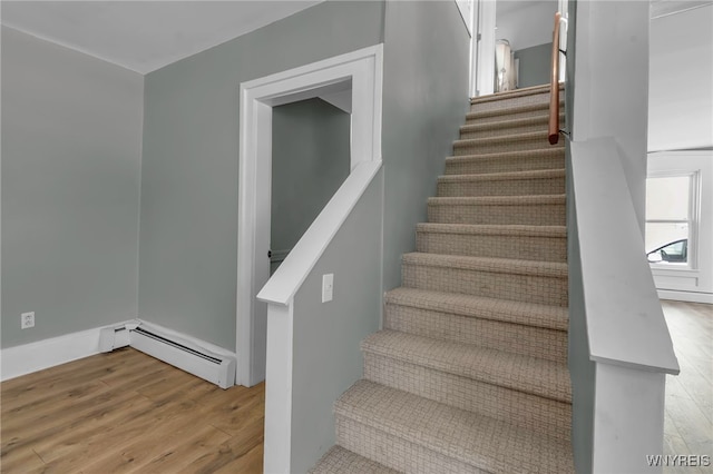 stairs featuring hardwood / wood-style flooring and a baseboard radiator