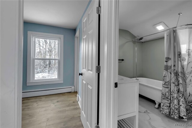 bathroom with hardwood / wood-style flooring, a baseboard radiator, lofted ceiling, and shower / tub combo with curtain