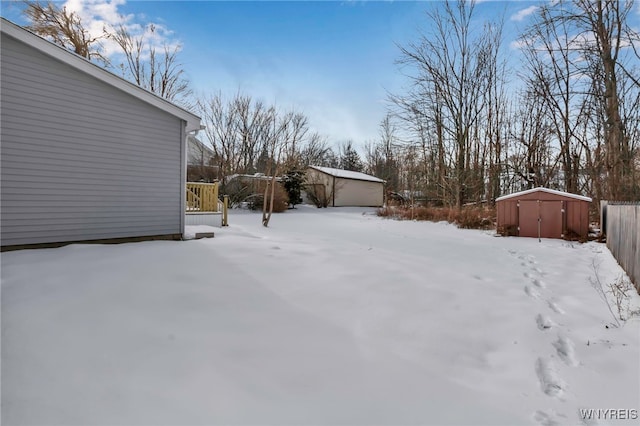 yard covered in snow featuring a storage shed