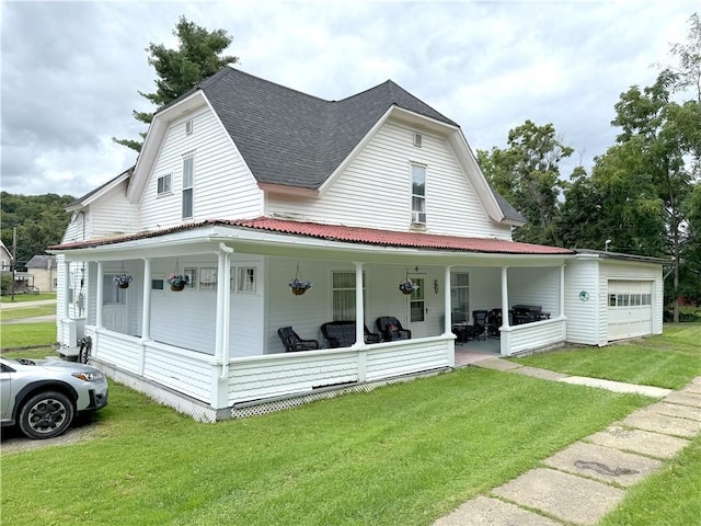 farmhouse-style home with a front yard, covered porch, and a garage