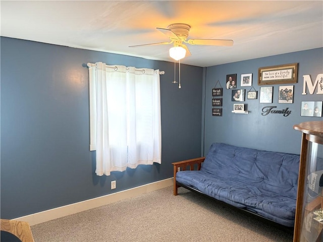 sitting room with ceiling fan and carpet