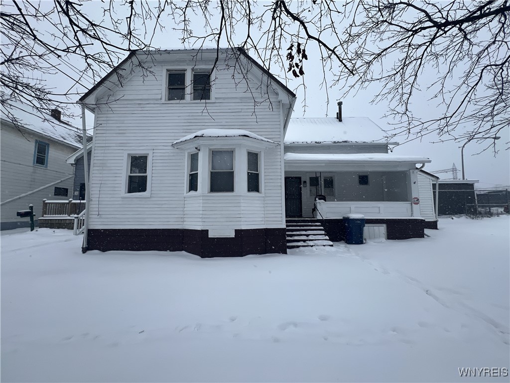 snow covered property with a porch