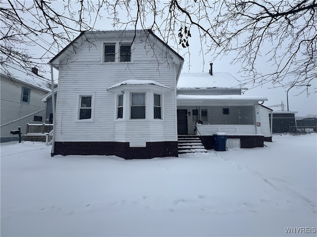 snow covered property with a porch