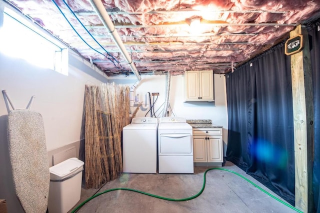 clothes washing area with washing machine and dryer and cabinets