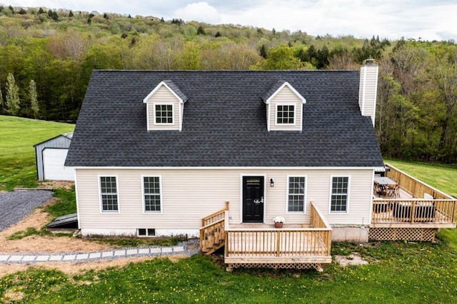 rear view of house featuring a wooden deck and a lawn