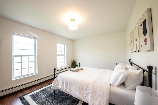 bedroom featuring a baseboard heating unit and dark hardwood / wood-style floors