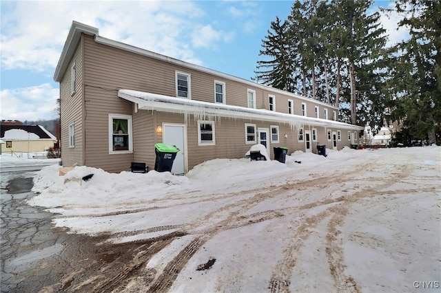 view of snow covered rear of property