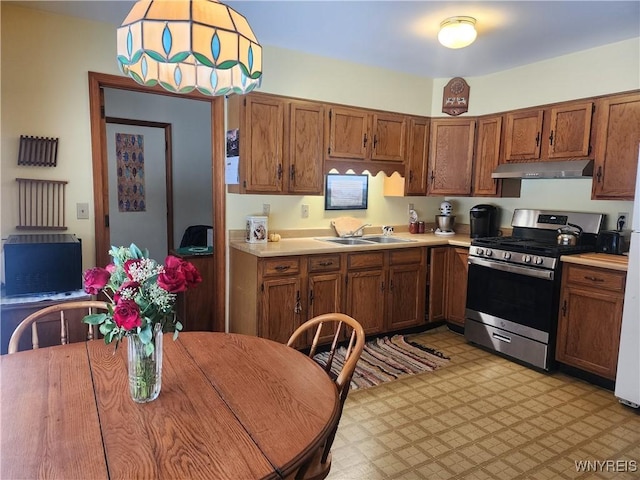 kitchen with stainless steel range with gas cooktop, pendant lighting, and sink