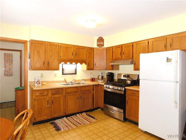 kitchen featuring white fridge, gas range, and sink