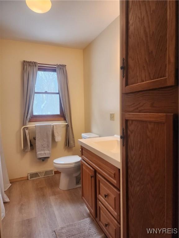 bathroom featuring toilet, hardwood / wood-style floors, and vanity