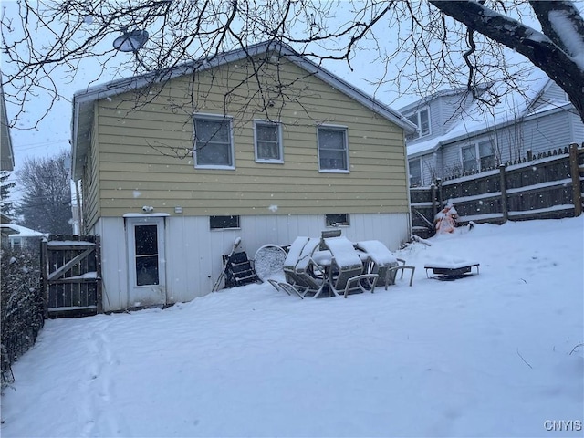 view of snow covered rear of property