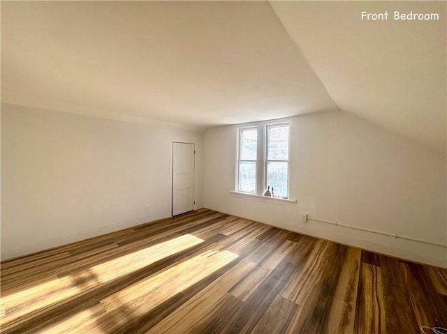 additional living space with vaulted ceiling and hardwood / wood-style flooring