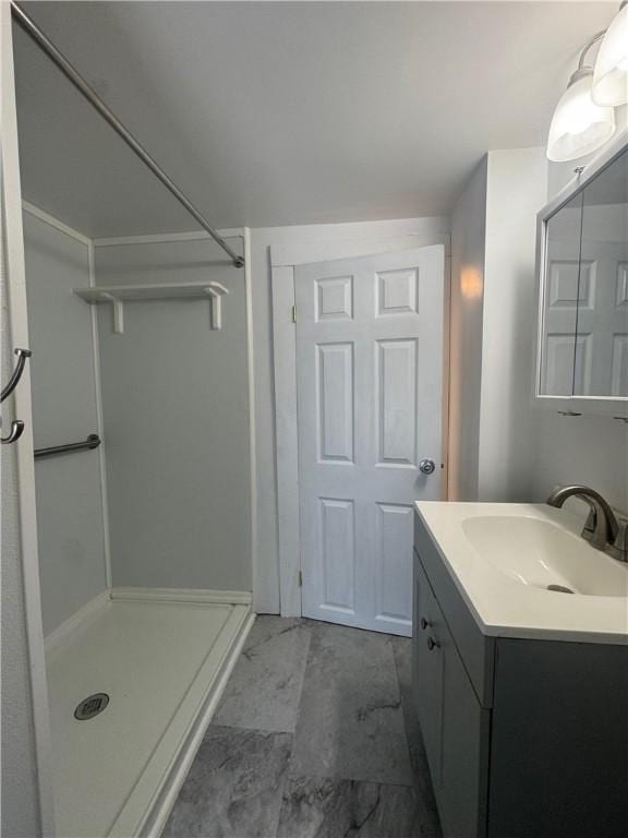 bathroom featuring a shower and vanity