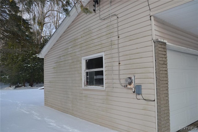 snow covered property with a garage