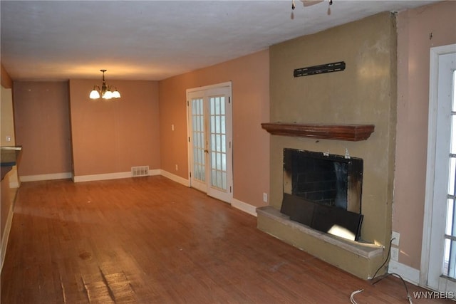 unfurnished living room with a chandelier and hardwood / wood-style flooring