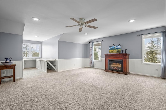 carpeted living room with ceiling fan, vaulted ceiling, and a healthy amount of sunlight