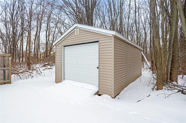 snow covered structure with a garage