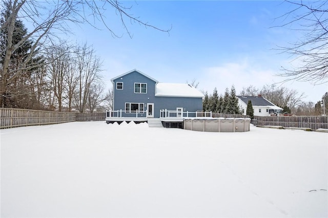 snow covered house with a pool side deck