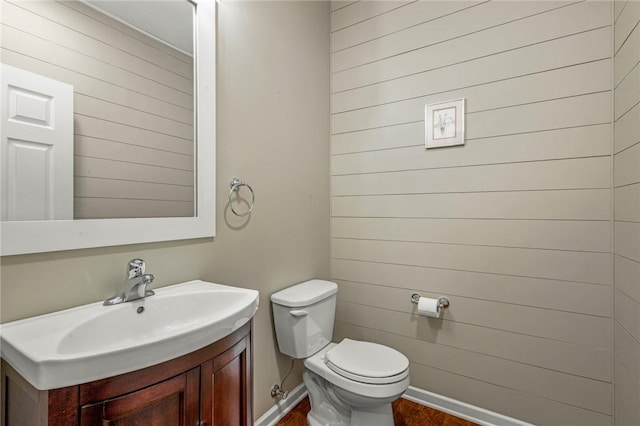 bathroom with toilet, hardwood / wood-style flooring, and vanity