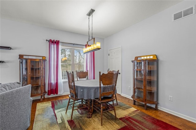 dining area featuring dark hardwood / wood-style flooring and a chandelier