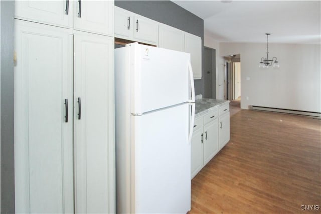 kitchen featuring pendant lighting, white cabinetry, white refrigerator, a notable chandelier, and light hardwood / wood-style flooring