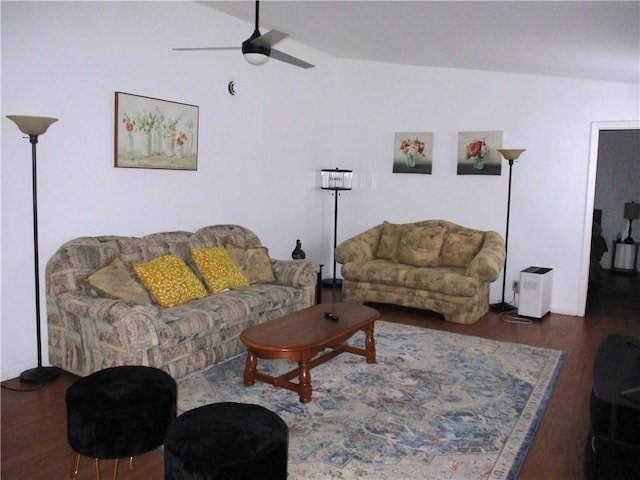 living room with lofted ceiling, ceiling fan, and dark wood-type flooring