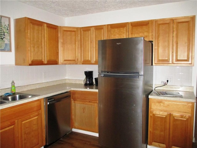 kitchen featuring dark wood-type flooring, backsplash, appliances with stainless steel finishes, and a textured ceiling