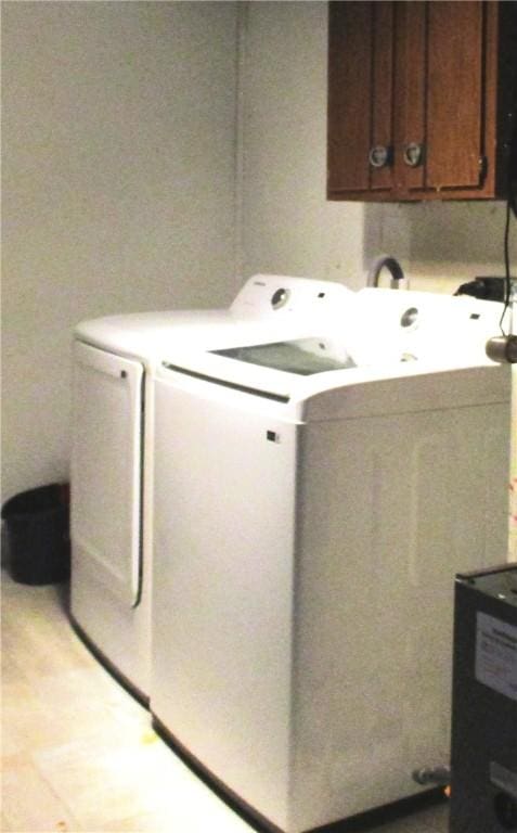 washroom with cabinets, separate washer and dryer, and light tile patterned floors